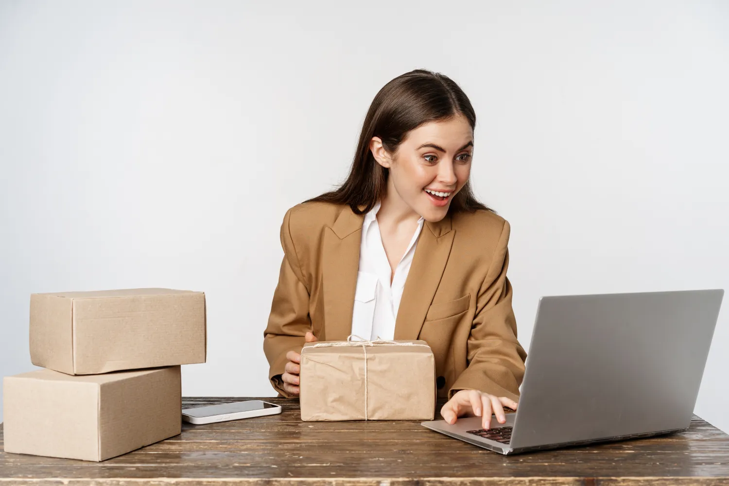 Amazon seller managing orders and a parcel at a laptop