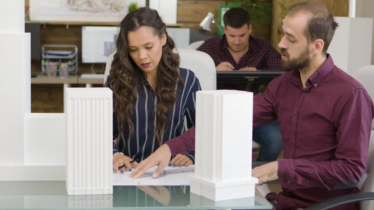 Architect studying a scale model of a building