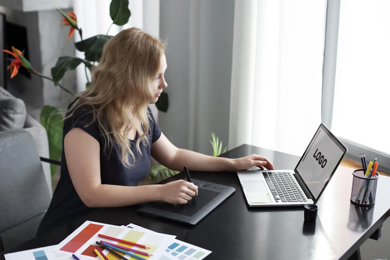 Designer working on a logo at a laptop