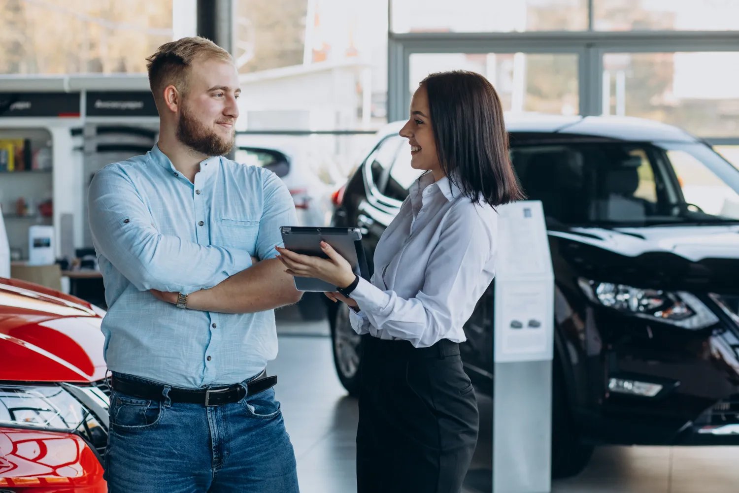 Salesperson showing a car to a customer