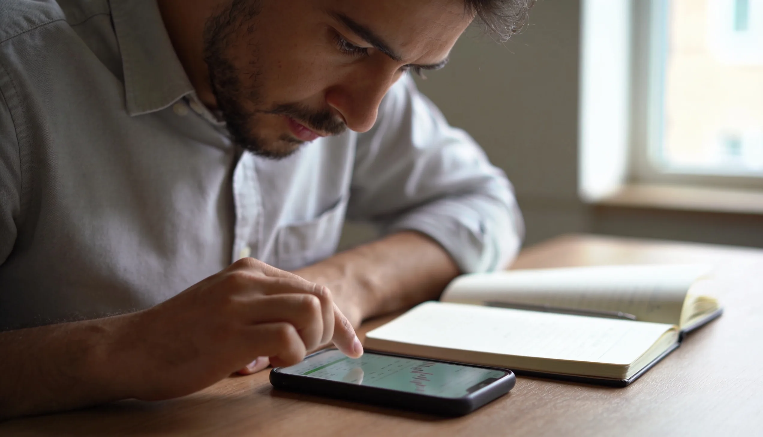 Business owner reviewing SEO investment and finances on a phone and notebook