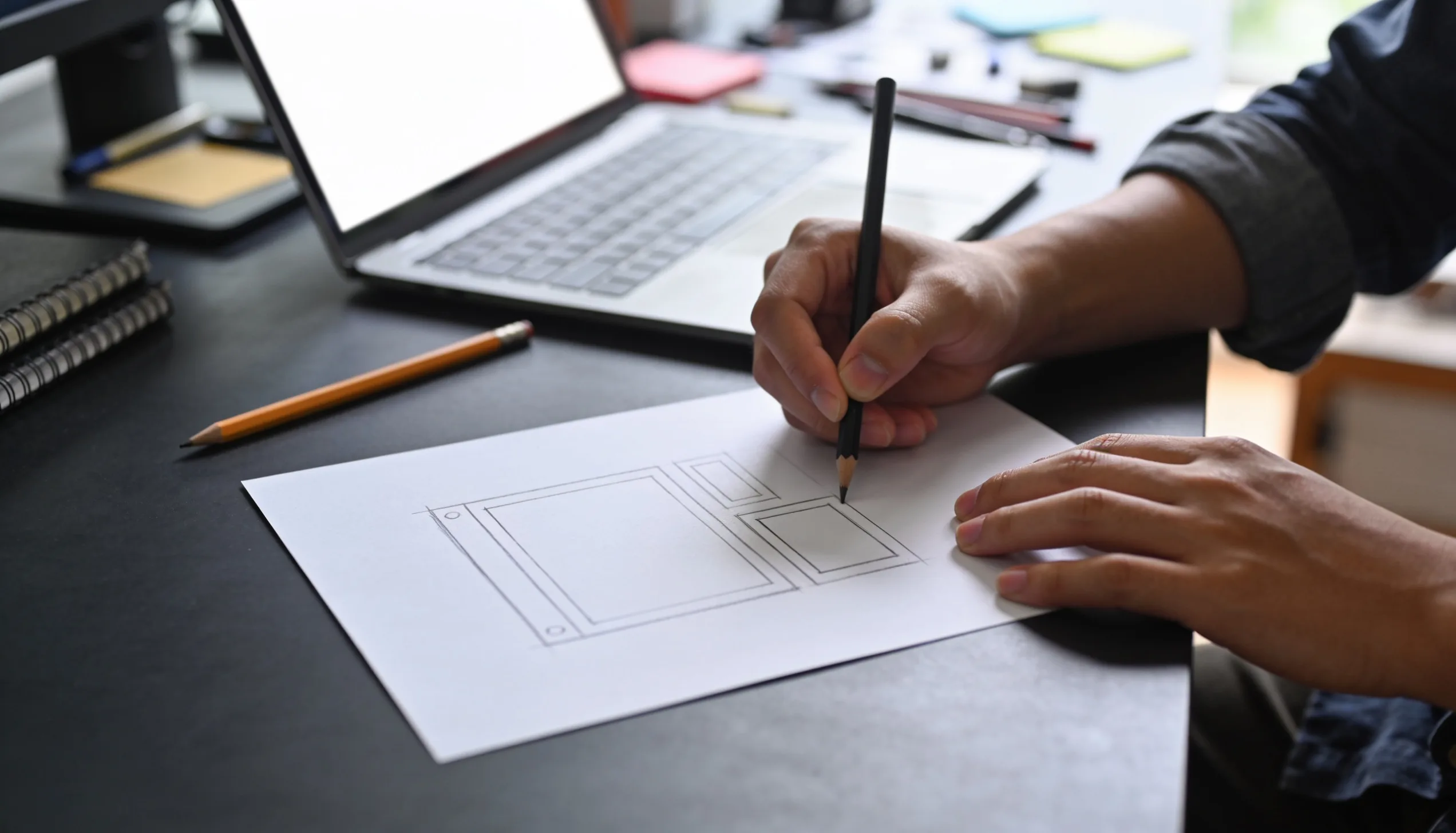 Designer sketching website wireframes to improve conversions