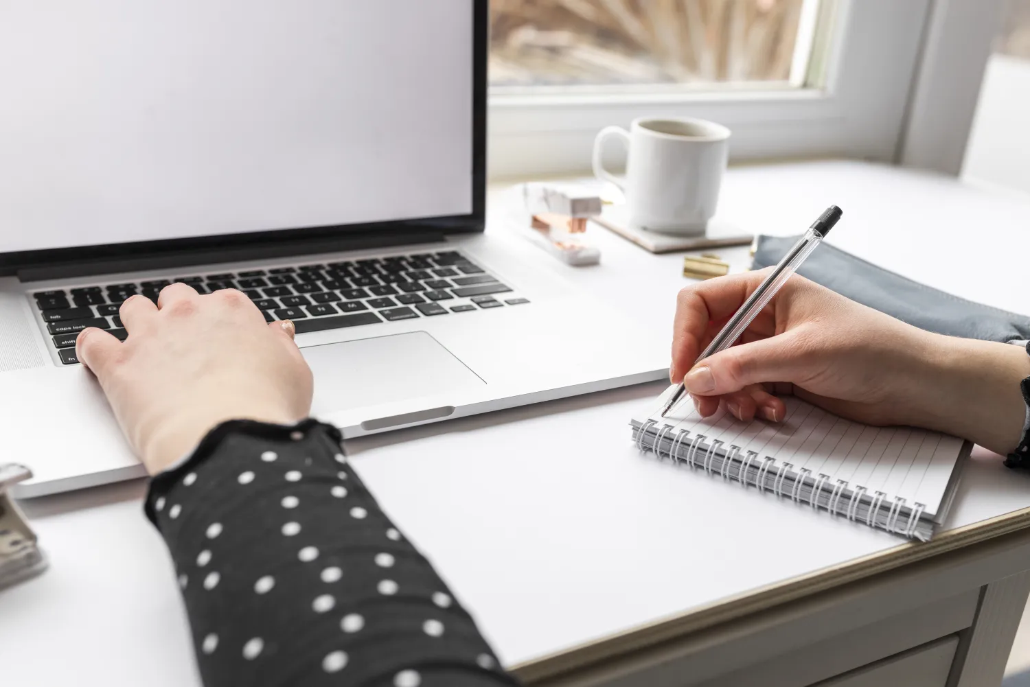 Writer planning content and notes beside a laptop