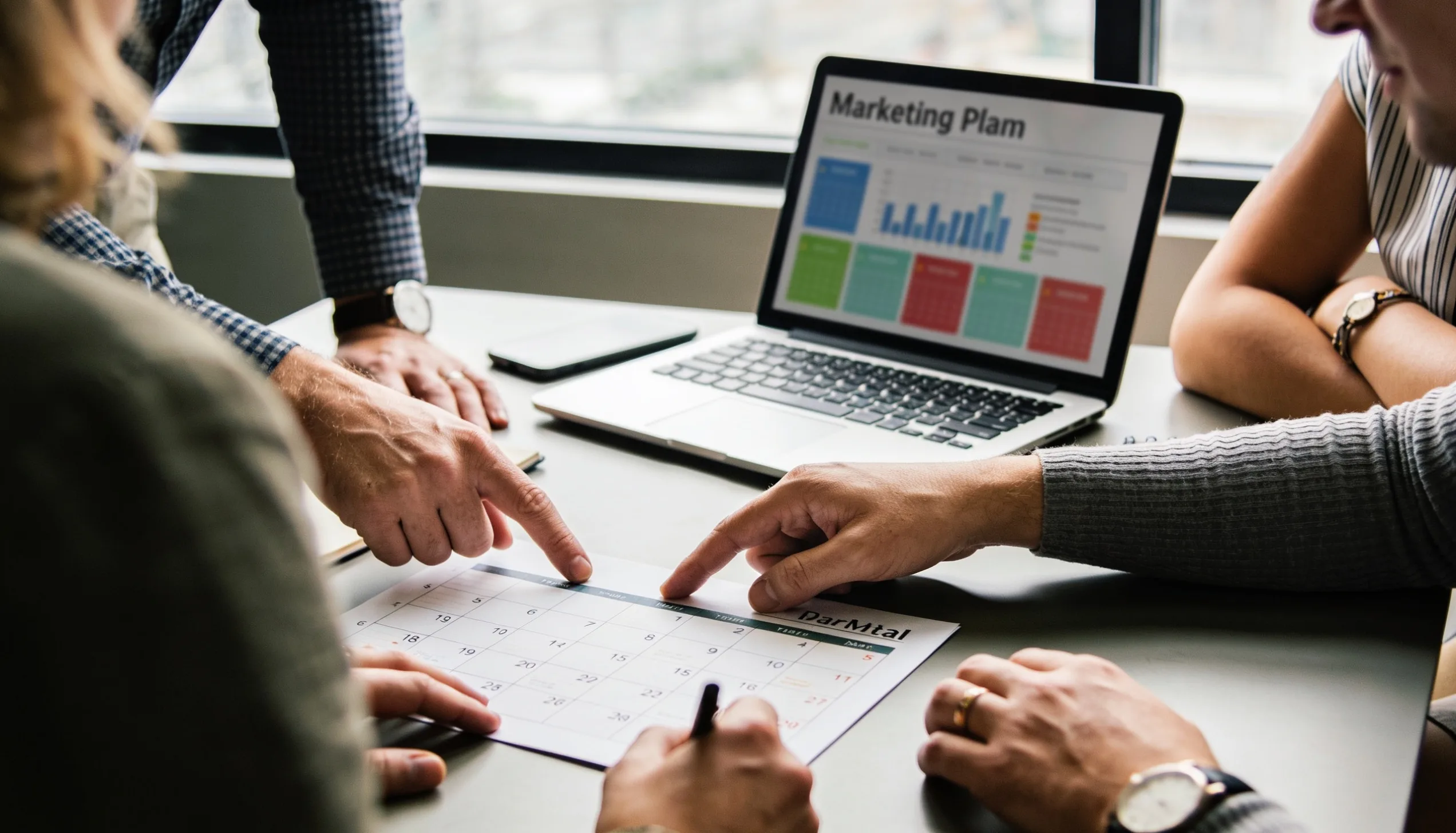 Team reviewing a month-by-month digital marketing plan and analytics