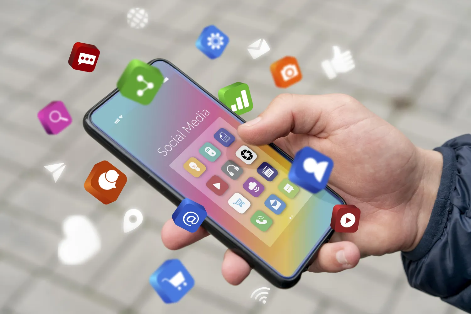 Hand holding a phone surrounded by social media app icons