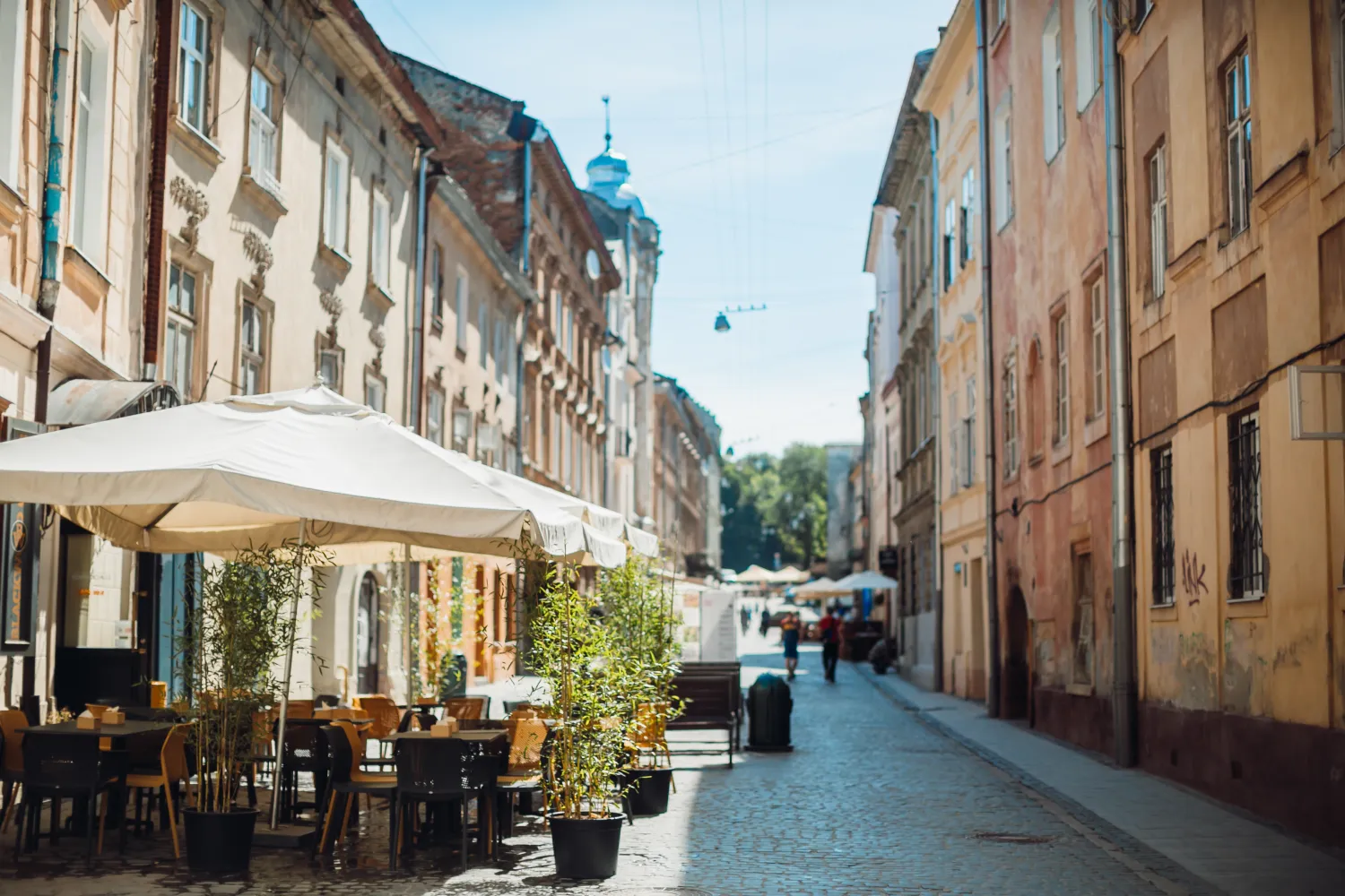 Storefronts and cafe tables along a street