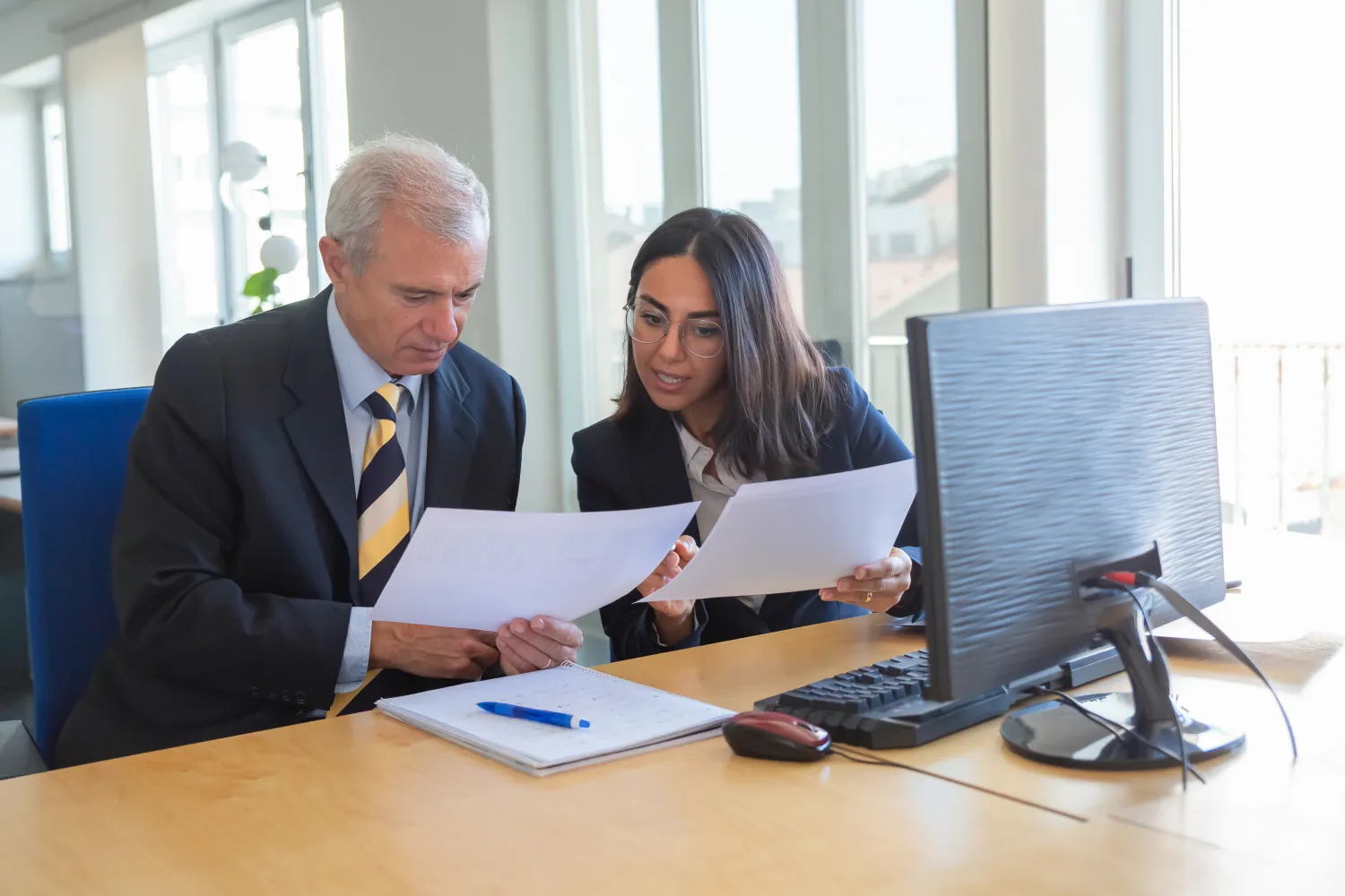 Solicitor advising a client across a desk in a law office
